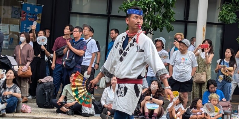 Char Nebuta en plein jour. Premier plan : homme avec un sifflet menant le groupe
