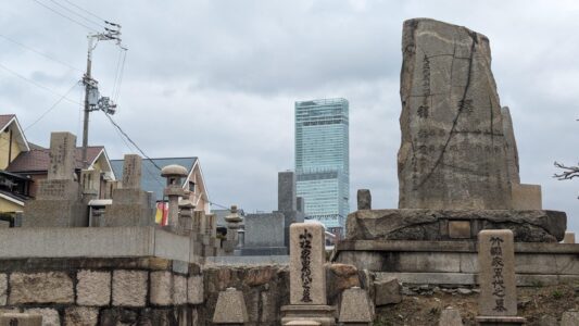 Influences coréennes Image de bâtiments modernes dans le quartier coréen d'Osaka, avec des éléments d'architecture contemporaine et un petit cimetière traditionnel niché entre les structures urbaines