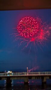 "Défilé nocturne des chars Nebuta illuminés avec feu d’artifice éclatant en arrière-plan lors du festival Nebuta d’Aomori
