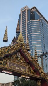 Vue d'un temple thaïlandais traditionnel avec un bâtiment moderne en arrière-plan à Bangkok