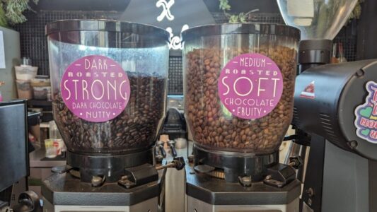 Gros plan sur des grains de café dans une machine à moudre dans un café à Bangkok