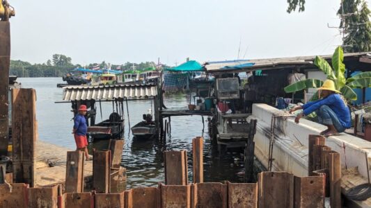 Homme thaïlandais portant un chapeau de paille dans le parc Bangkachao, entouré de tuiles et de bananiers