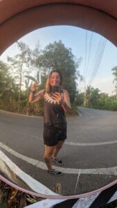 Inès souriante en short, prenant une photo dans le parc Bangkachao à Bangkok