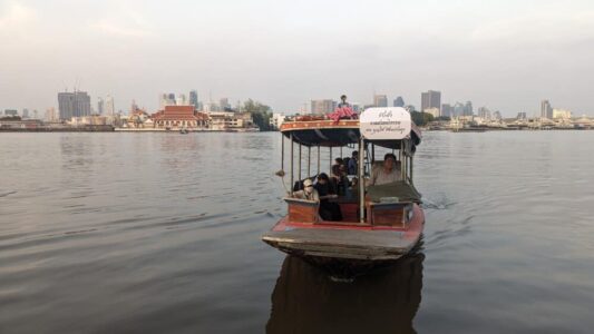 Petite navette sur l'eau au coucher du soleil, offrant une vue paisible à Bangkok