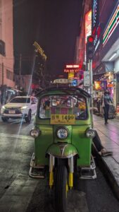 Tuk-tuk vert vu de face, illuminé la nuit à Bangkok