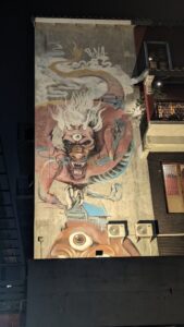 Illustration de street art représentant un dragon sur un mur, de nuit, à Bangkok
