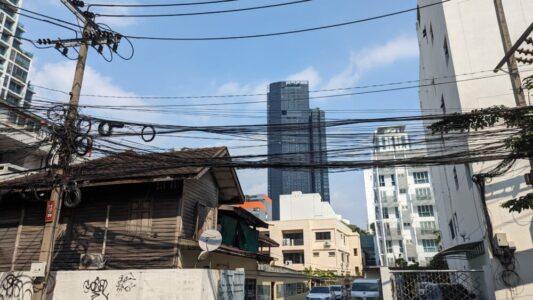 Vue d'une rue à Bangkok, montrant l'architecture locale, des fils électriques et des monuments