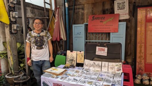 Portrait d'un homme thaïlandais souriant en train de vendre des cartes postales dans les rues de Bangkok