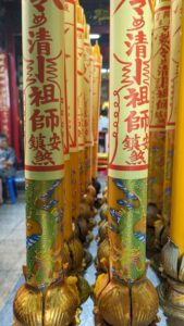 Gros plan sur des bougies allumées dans un temple à Bangkok, créant une atmosphère spirituelle
