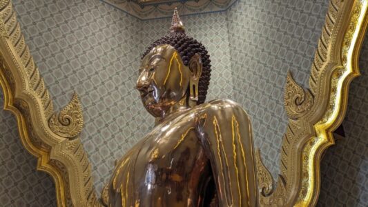 Illustration d'un temple à Bangkok avec une grande tête de Bouddha dorée, symbole de la spiritualité thaïlandaise
