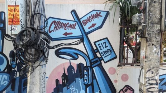 Illustration de street art montrant des panneaux de direction colorés et artistiques dans les rues de Bangkok