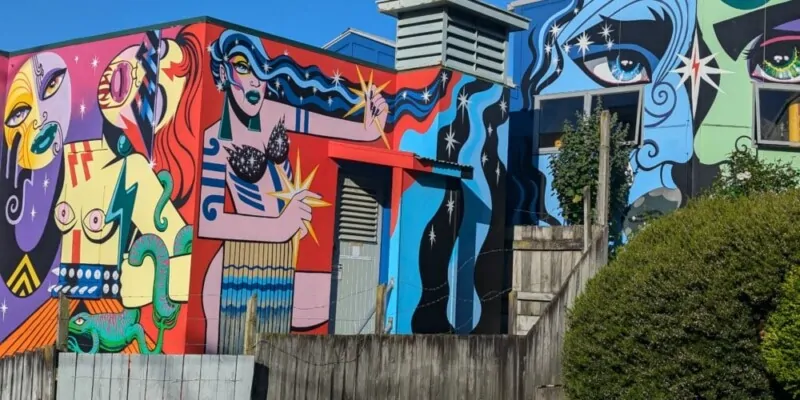 Fresque murale à Wellington d'une femme maorie aux couleurs vibrantes dans un style pop art. L'œuvre reflète l'identité culturelle néo-zélandaise avec une touche moderne