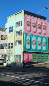Œuvre de street art pop vibrante sur un mur à Wellington, avec des couleurs audacieuses et des motifs modernes. L'art urbanise l'architecture de la ville