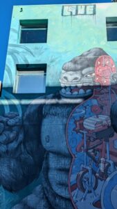Un mur décoré de street art vibrant à Wellington, où l'architecture urbaine se mêle à des œuvres artistiques modernes. L'espace urbain devient une galerie en plein air