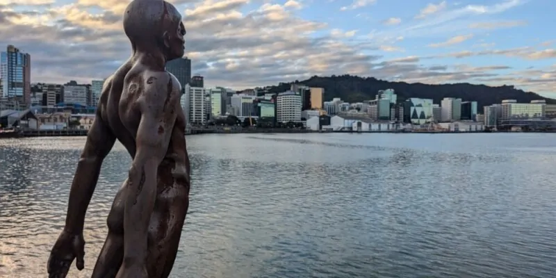 Sculpture d'un homme en plein art, statue face au port de Wellington, avec des mains tendues vers l'avant
