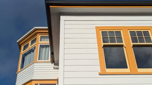 Maison architecturale à Wellington, peinte en jaune vif, se distinguant dans le paysage urbain